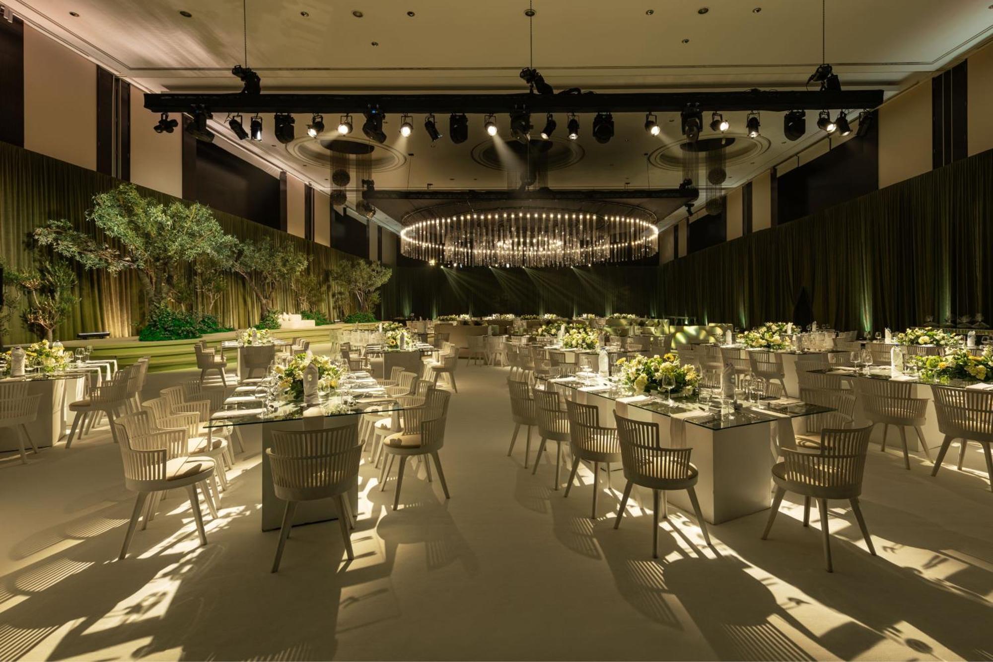 Le Meridien Dubai Hotel & Conference Centre Exterior photo The photo shows an elegantly designed banquet or event space. The room features several tables arranged with white tablecloths, each set with plates, glasses, and floral centerpieces. There are modern, light-colored chairs around the tables. The ambi